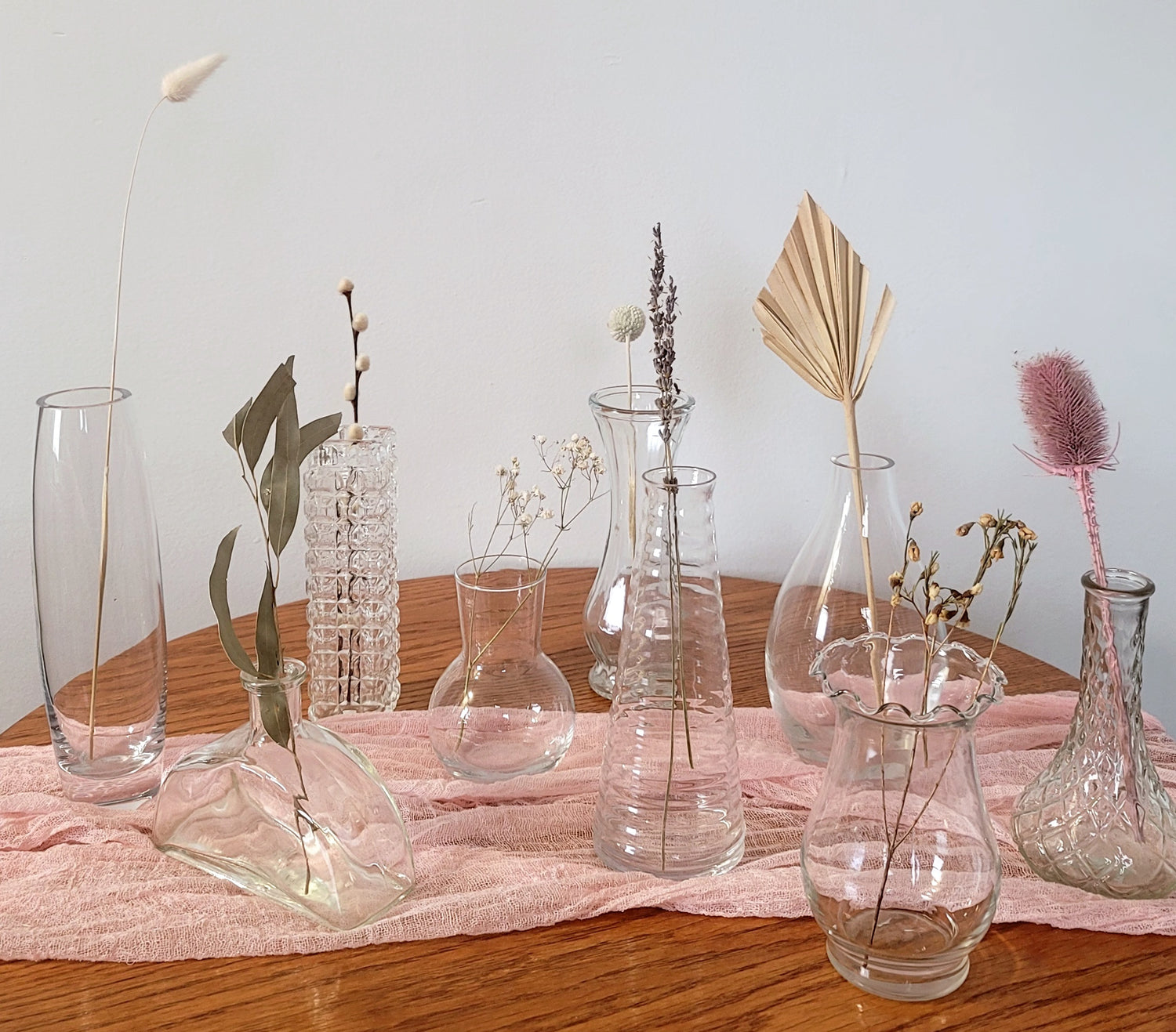 A collection of vintage mismatched clear glass bud vases, to make every table unique at your wedding or special event. Mismatched bud vase collection available for rent in Winnipeg and surrounding areas.